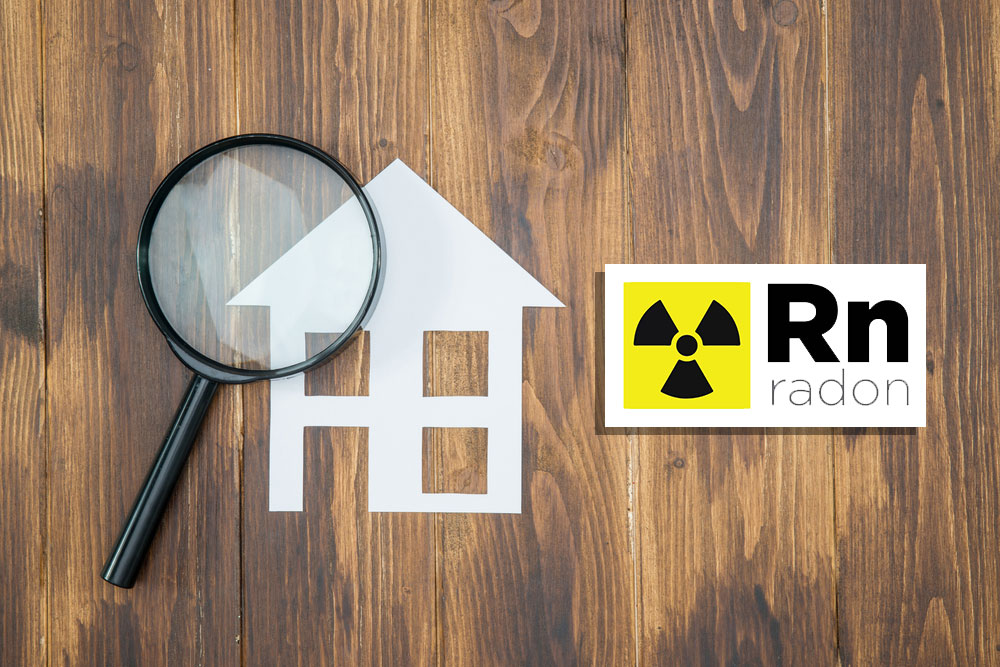 magnifying glass over a house with radon symbol